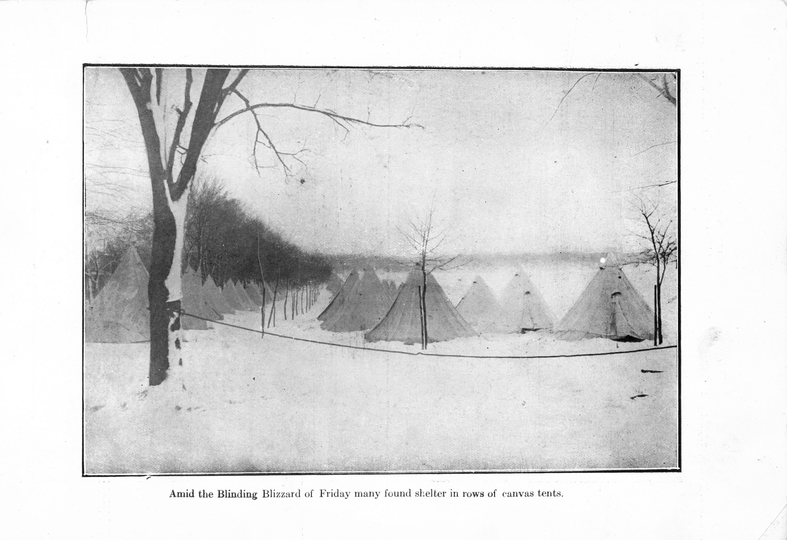 Black and white photo of rows of canvas tents in the snow with caption “